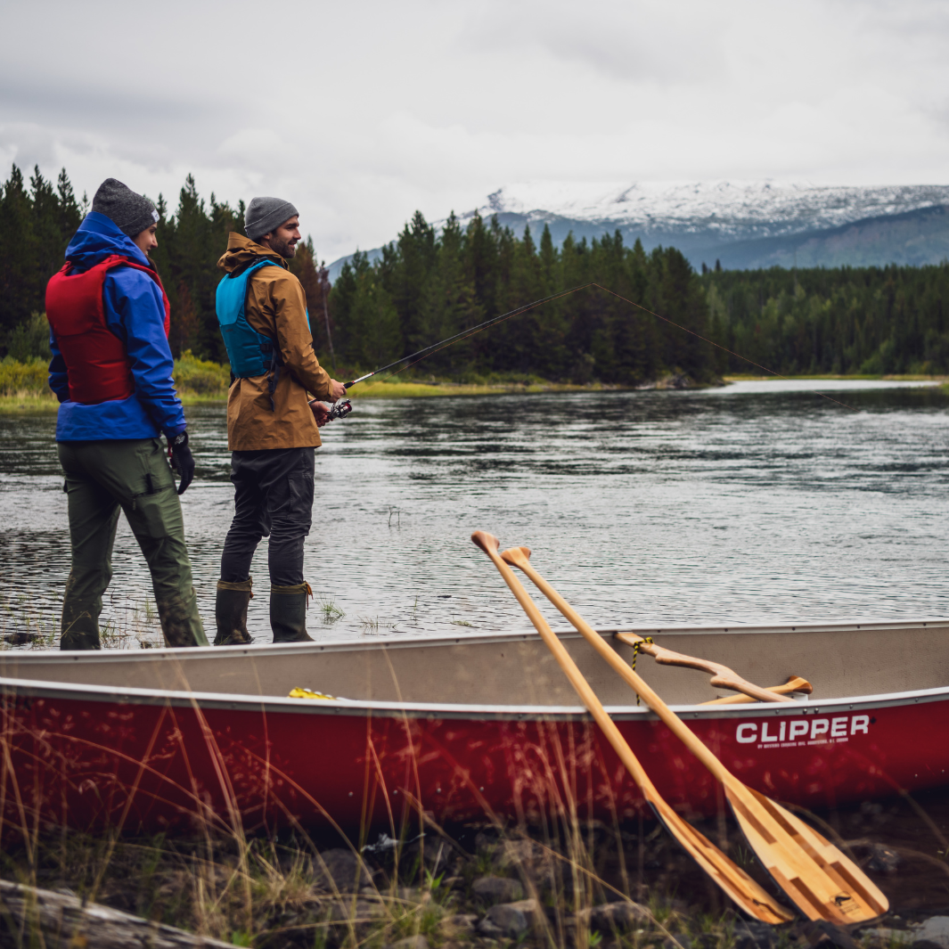 Catalyst 11 and Catalyst ST leaning against red canoe with two men fishing in the background